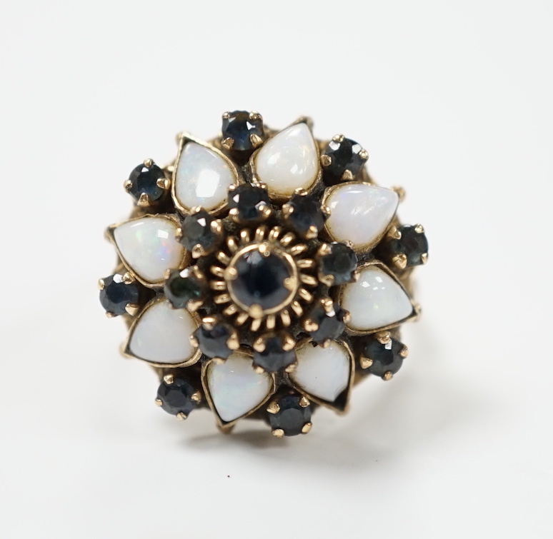 An 18k, white opal and sapphire set domed cluster dress ring, size O, gross weight 6.6 grams.